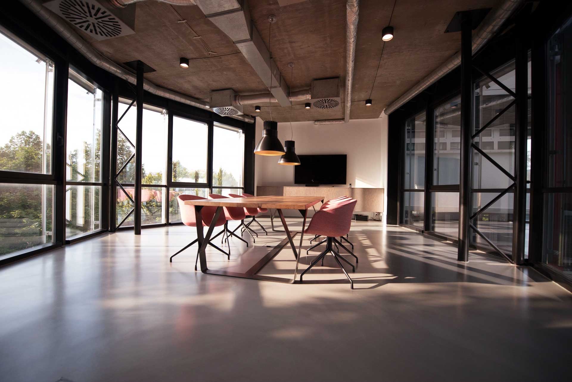 large office filled with sunlight and meeting table in the middle