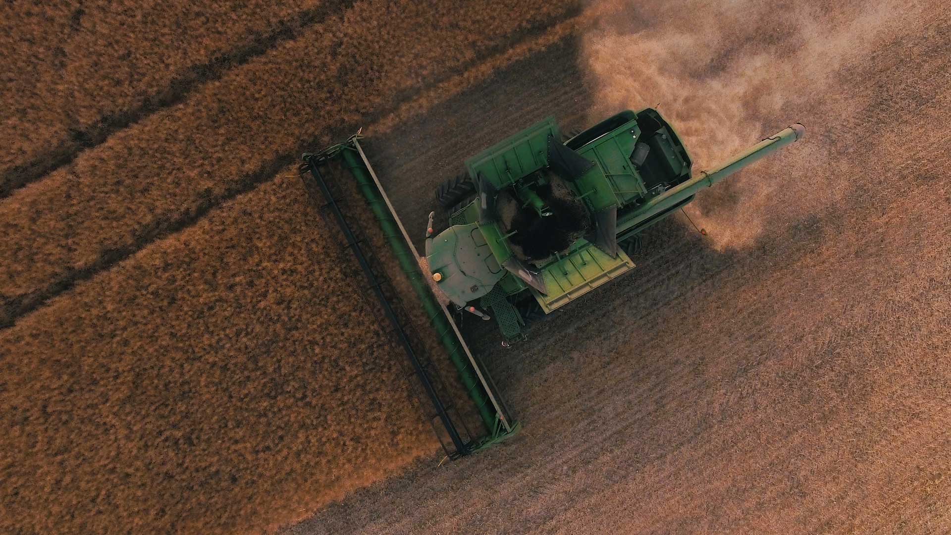 show of farm tractor mowing fields on farm from above